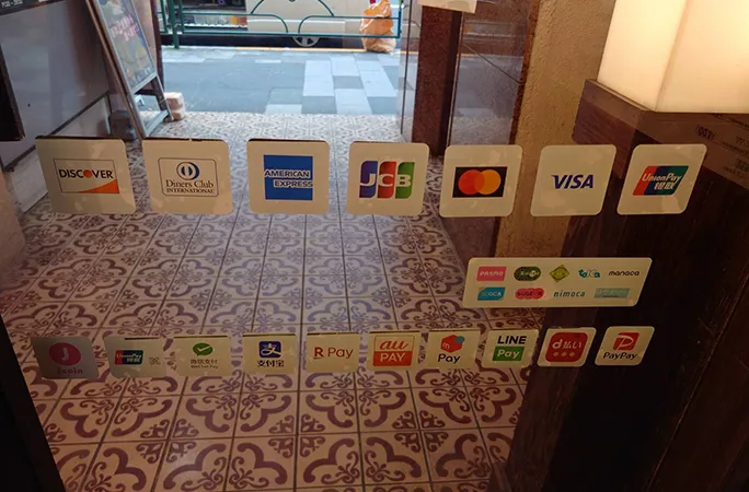 多彩なキャッシュレス決済に対応した店舗入口のステッカー表示。